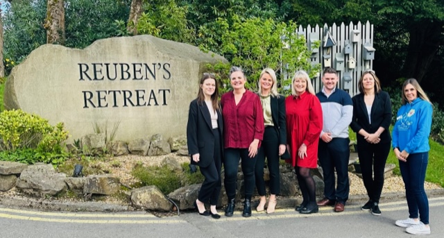 Team from O'Donnell Solicitors smiling for a photo at the entrance of Reuben's Retreat, showcasing their support for the charity